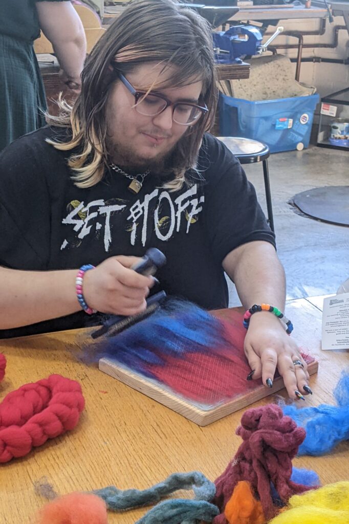 person doing art with wool