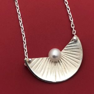 a metal necklace with pearl