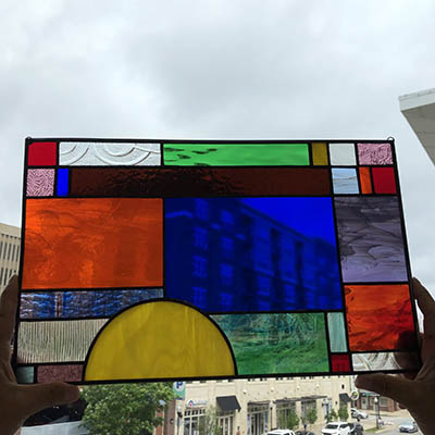 stained glass being held up against sky