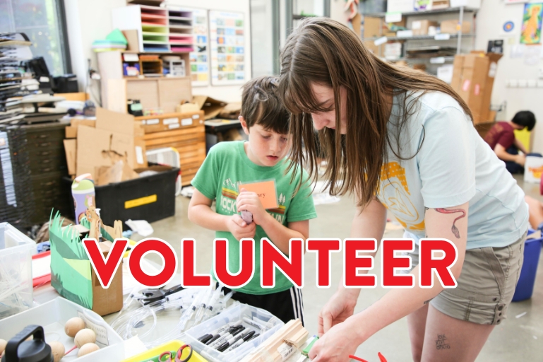 volunteer helping student with art project