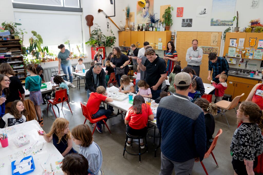 a room of individuals drawing and creating magnets