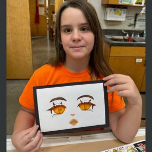 child holding up a marker drawing