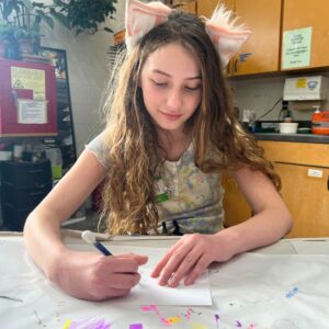 a preteen drawing at a table