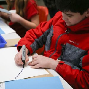 a child drawing with a black marker