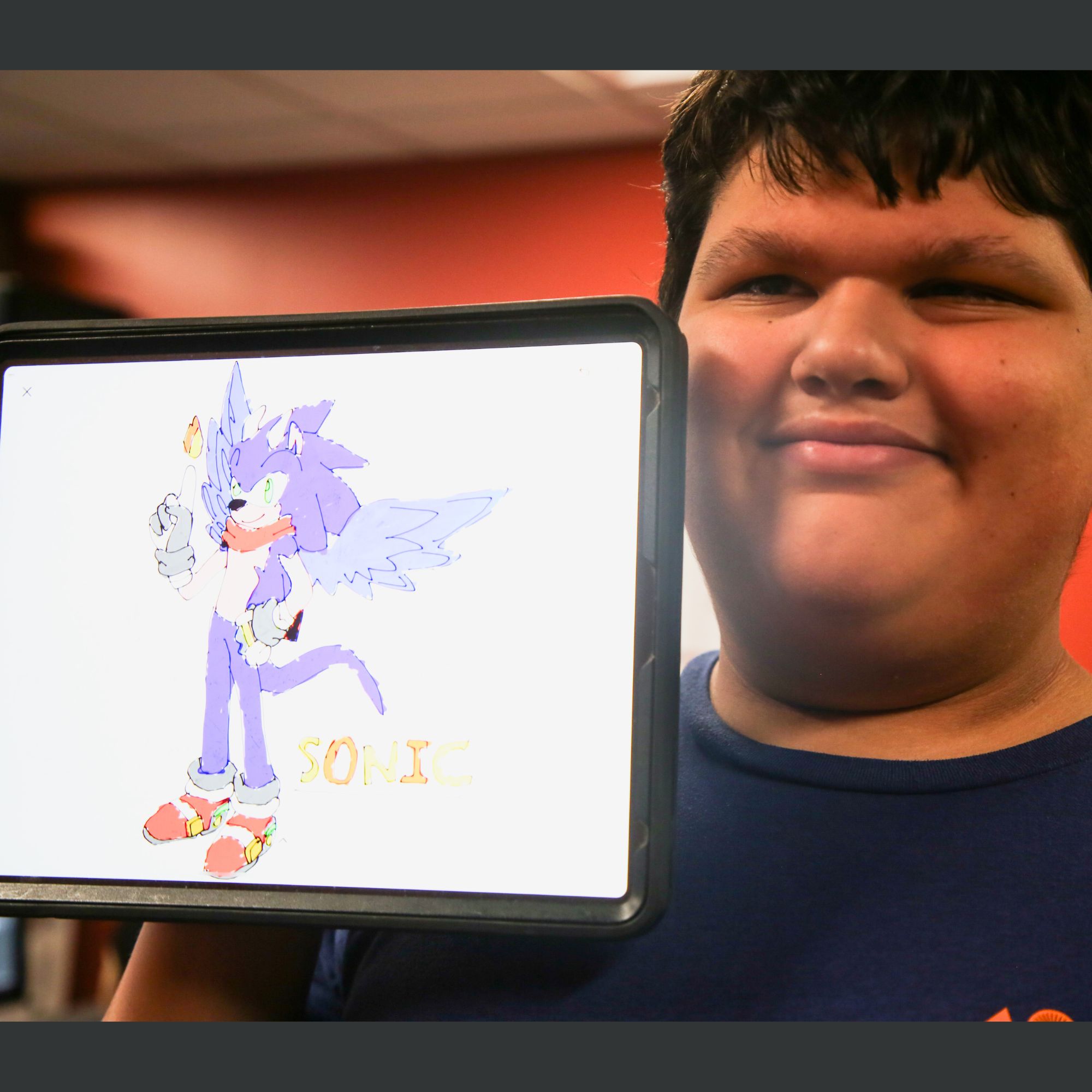 teen holding ipad with a drawing of Sonic the Hedgehog
