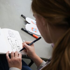 teen drawing in a sketchbook