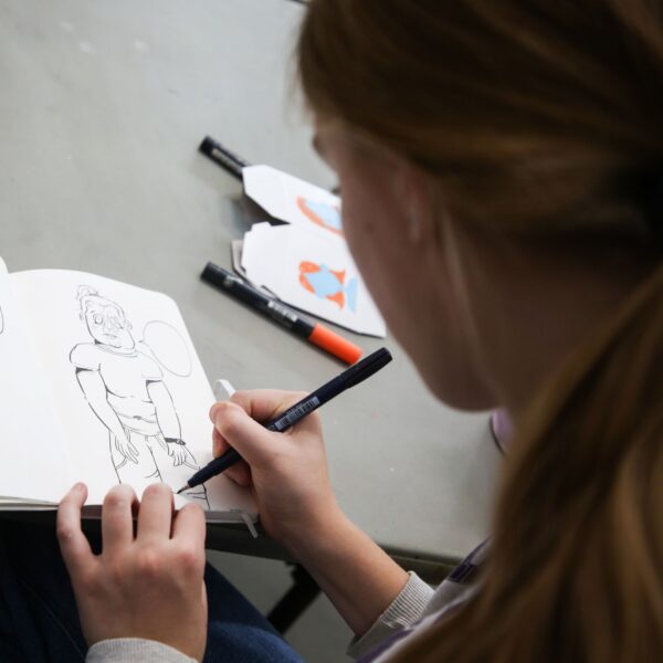 teen drawing in a sketchbook