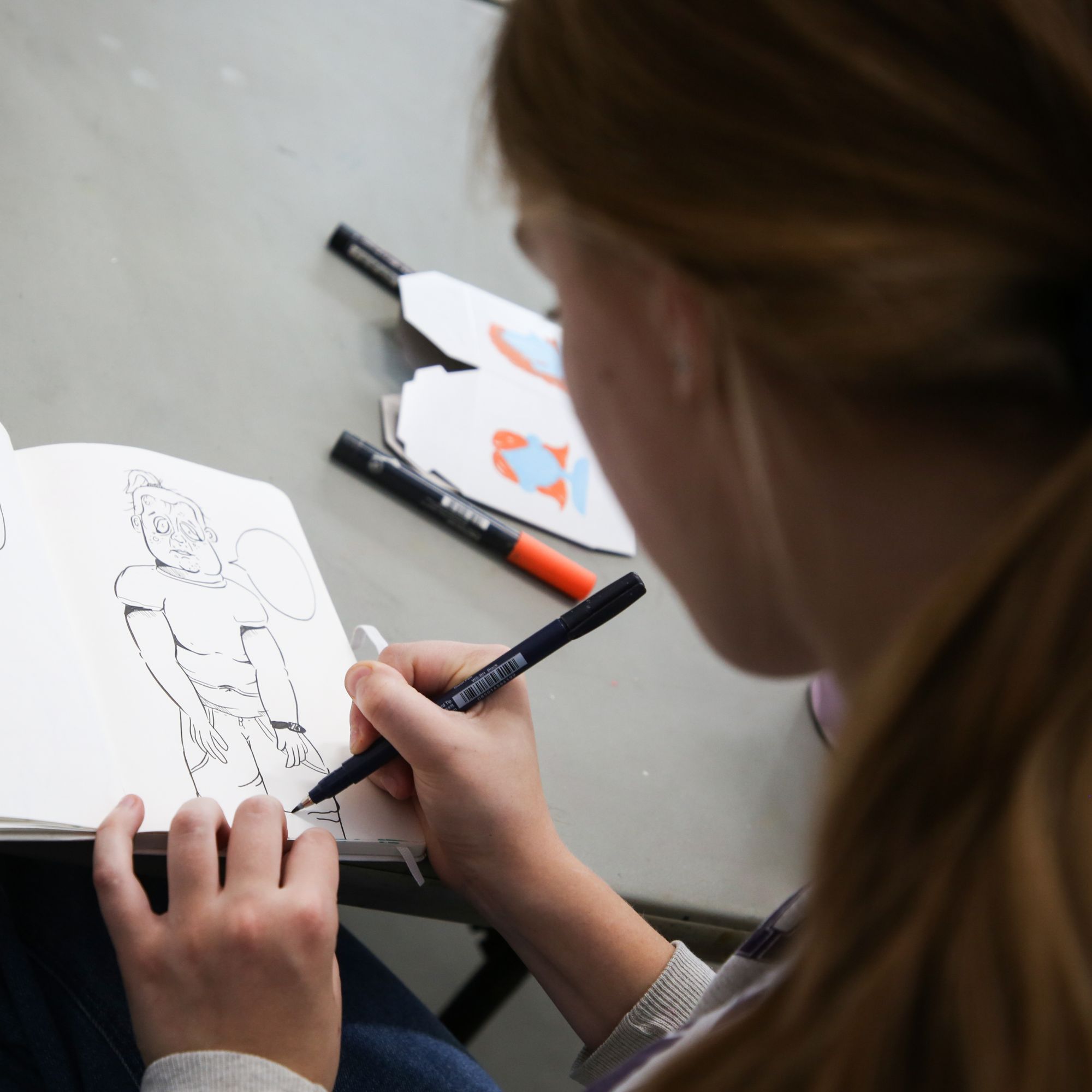 teen drawing in a sketchbook