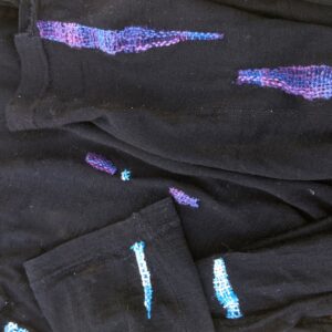 black shirts repaired with colorful thread