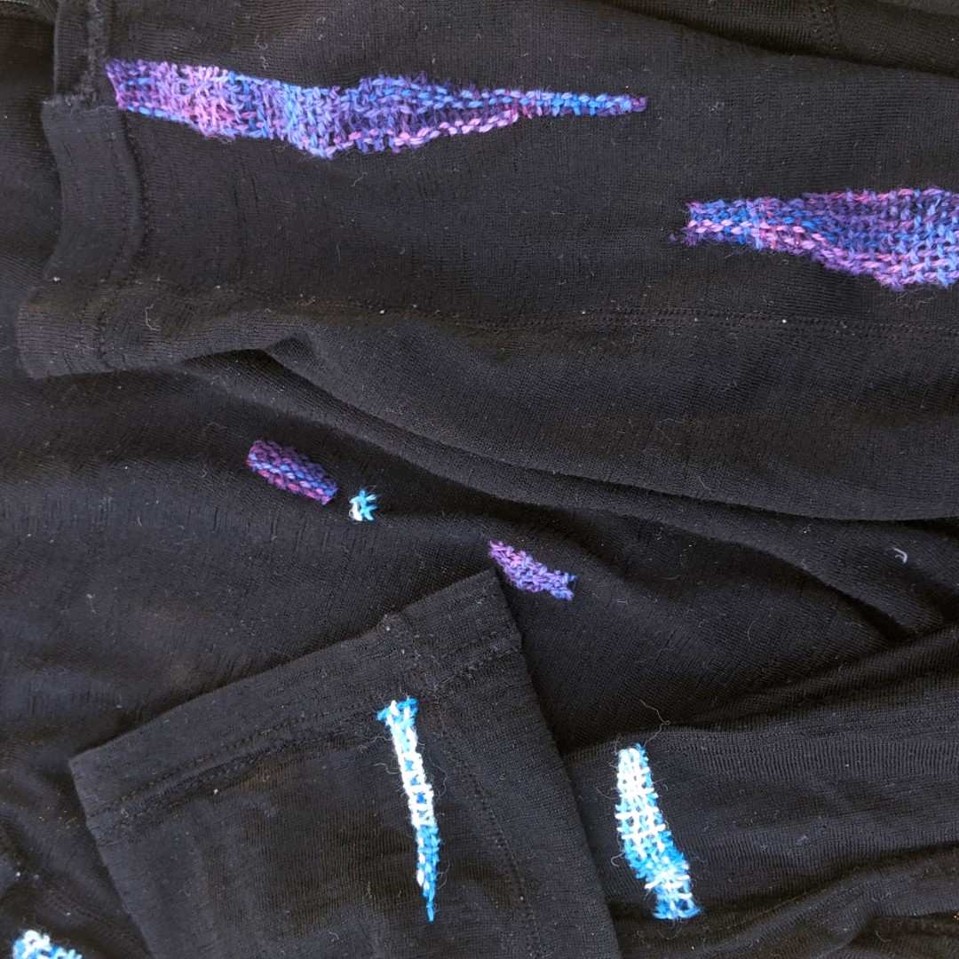 black shirts repaired with colorful thread
