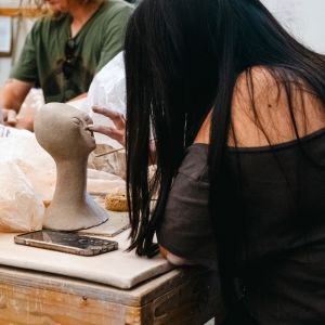 An artist working on a bust of an alien