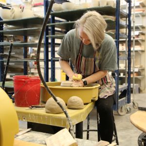 Woman at a pottery wheel making a bowl