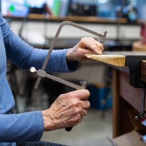 Hands using a jeweler's saw