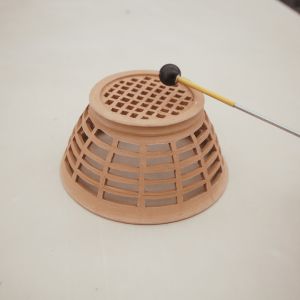 A mallet tapping an unglazed ceramic form