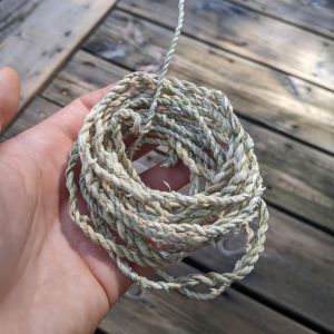 Hand holding a length of handmade twine